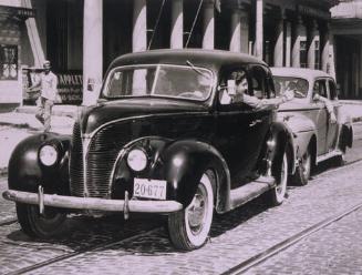 Untitled (Two cars, man gesturing)