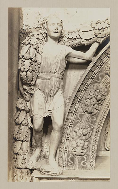 Youth bearing garland above head of bier